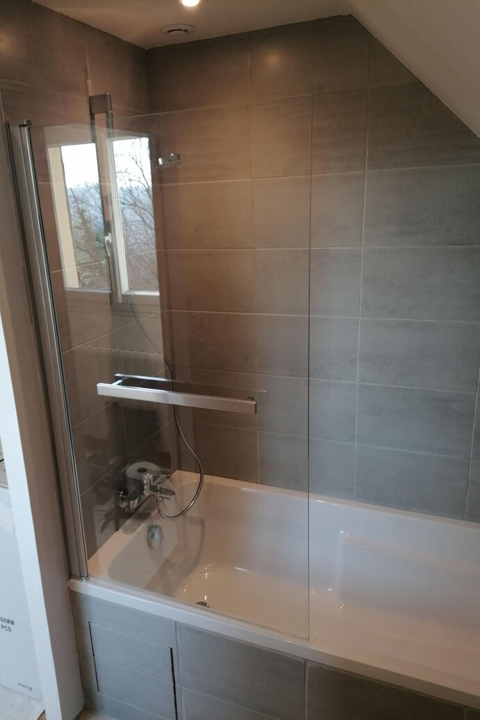 Baignoire sous-pente carrelée avec paroi pivotante